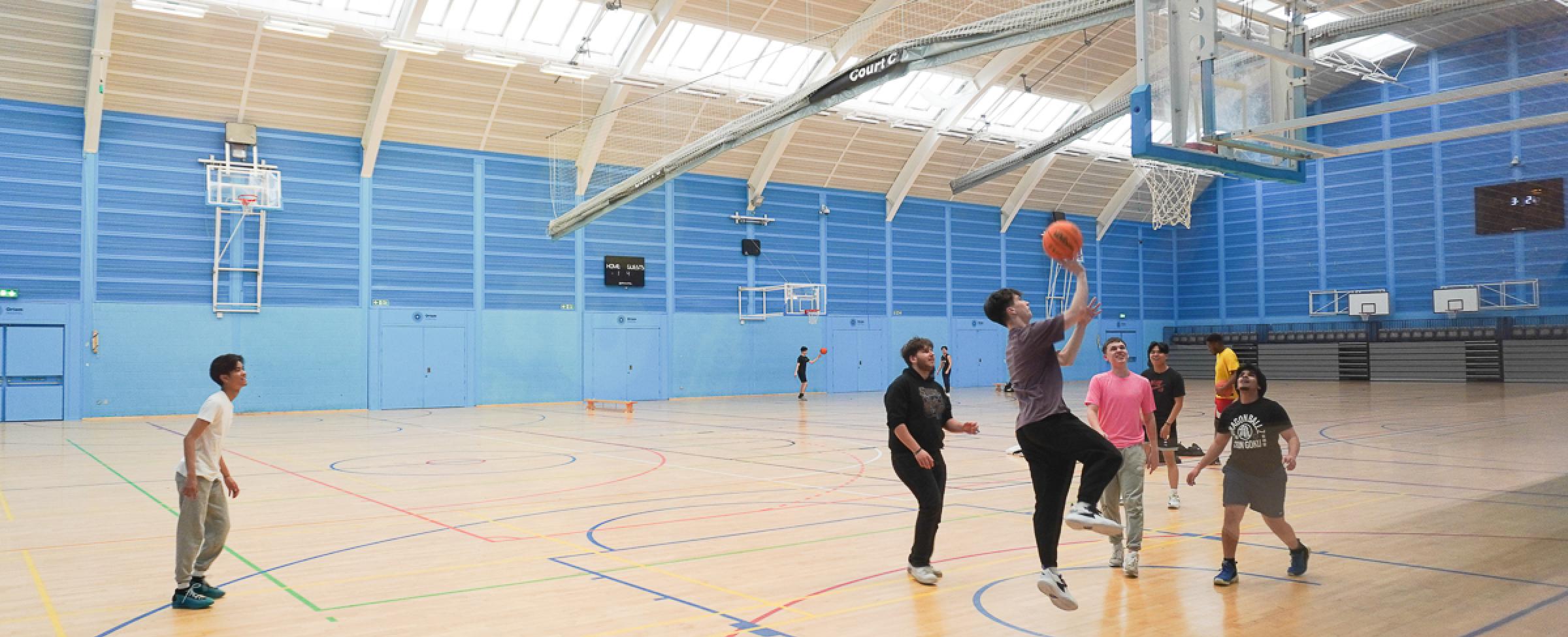 Youth playing basketball in a gym